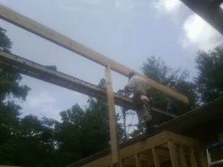 Carpenter setting a ridge beam over a new addition frame — Ice Dam Removal by Roofing Brothers in El Reno