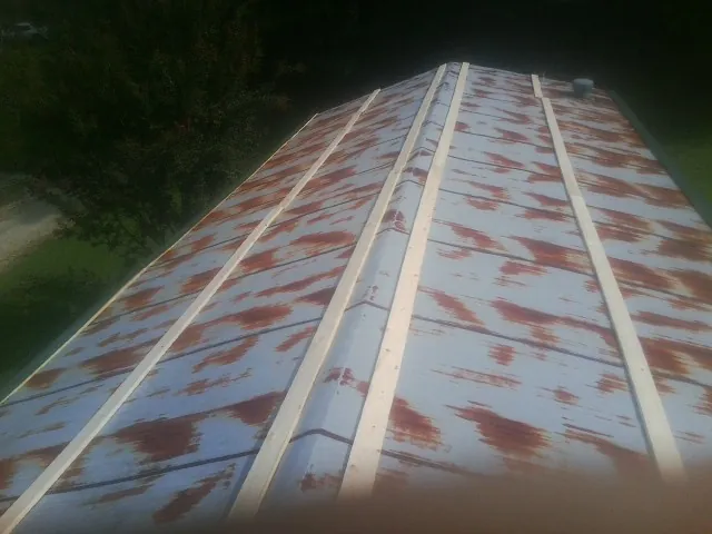 Rusted metal roof panels with new wood purlins before replacement — Storm Damage Roof Repair in El Reno by Roofing Brothers
