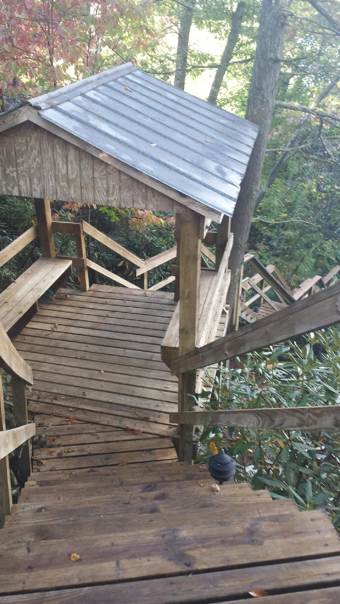 Metal roofed shelter over wooden steps on a wooded walkway — Skylight Repair & Installation work by our crew in El Reno