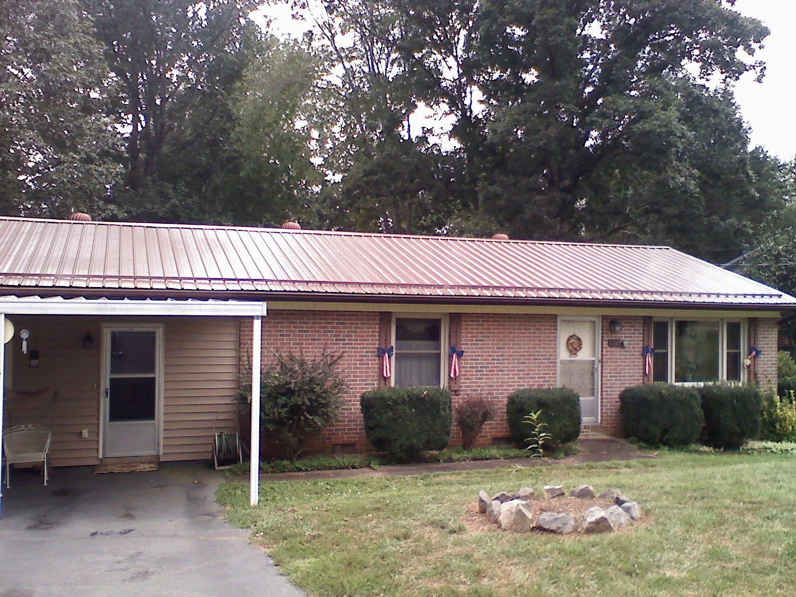 Bronze metal roof and carport on a brick ranch home — Roof Repair work by our crew in El Reno