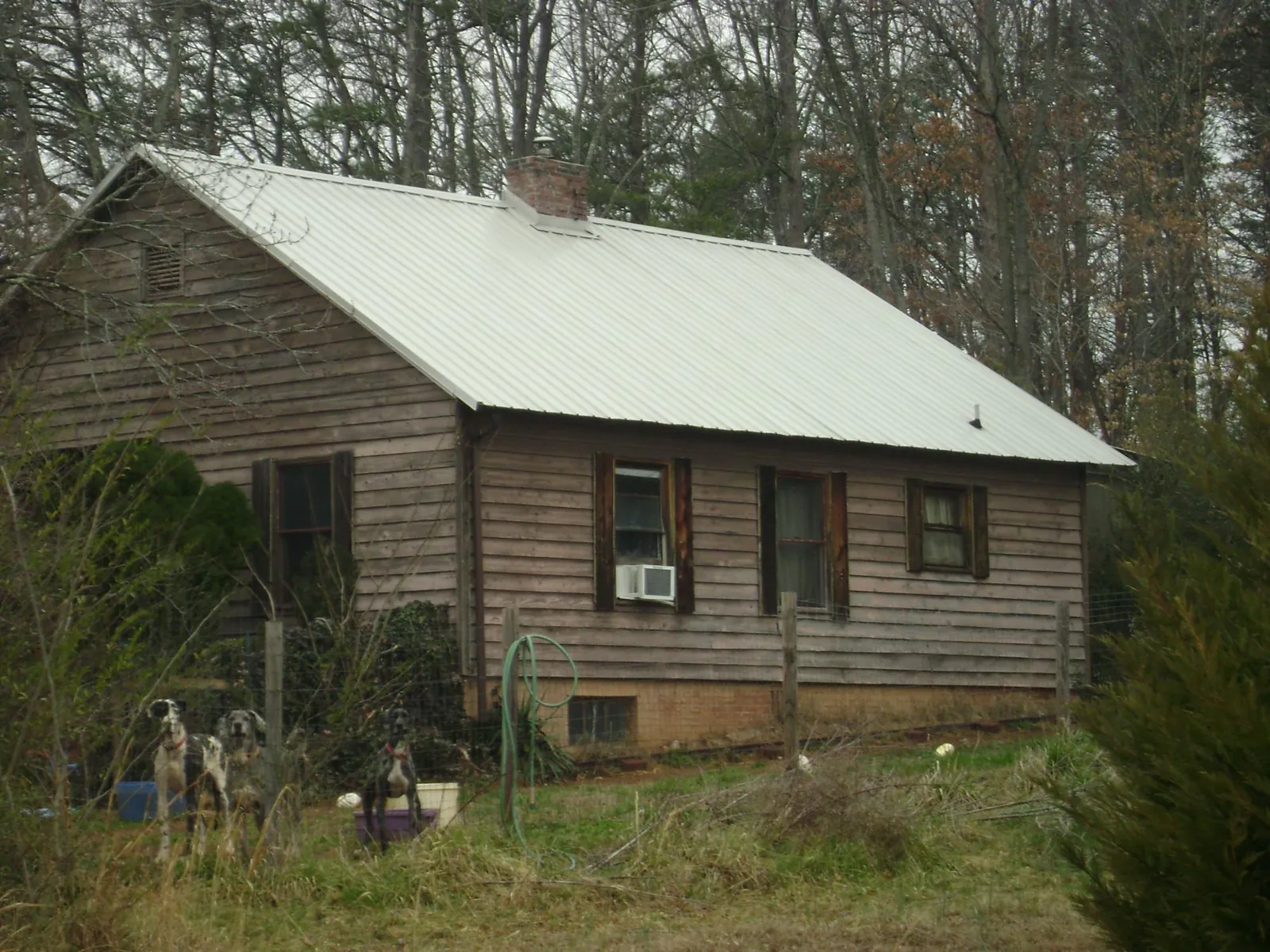 White metal roof on an old wood sided farmhouse, from a Metal Roof Installation job in El Reno
